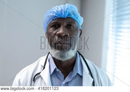 Portrait of african american male doctor wearing surgical cap and stethoscope looking to camera. medicine, health and healthcare services.