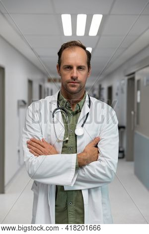 Portrait of caucasian male doctor standing with sthetoscope in hospital corridor. medicine, health and healthcare services.