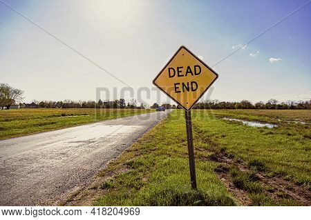 Dead End Road Sign With A Road Going To Horizon In The Background. Versatile Image For Bussiness Or 