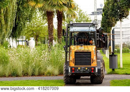 Heilbronn, Germany - August 12, 2019. A Small Tractor Cleans The Area Near Modern Houses Duringdurin