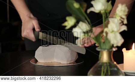 Man Cuts A Heart-shaped Cake With A Big Knife During A Celebration