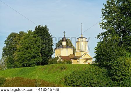 Wooden Church Of St. George The Victorious In Voronich Against The Blue Sky With Trees In The Backgr