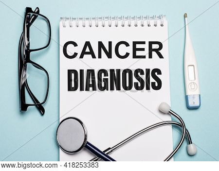 Cancer Diagnosis Written On A White Notepad Next To A Stethoscope, Goggles, And An Electronic Thermo