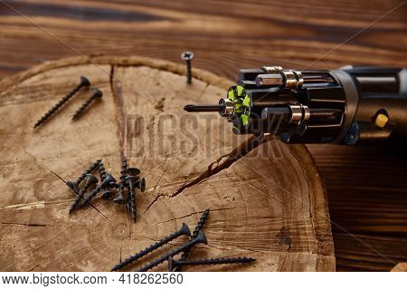 Screwdriver, self-tapping screws on stump, closeup