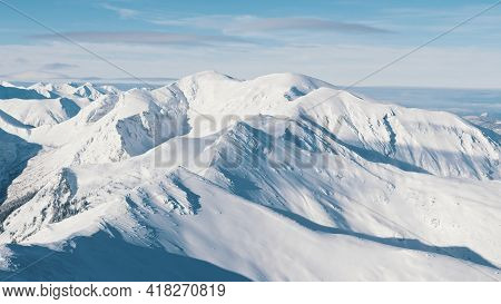 Snowy Mountains In The Winter Landscape With Cloudy Blue Sky During The Day Time. High Quality Photo