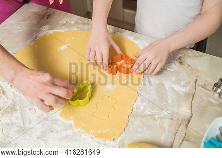 Hands Of Mother And Son Who Squeeze Cookie Figures On The Dough. Cooking At Home