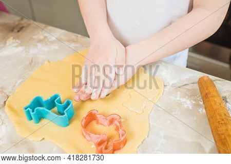 Child's Hands Squeezing Cookie Figures On The Dough. Cooking At Home