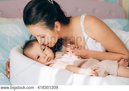 Young Single Mom Kissing Her Mixed Race Baby. Child Adoption And In Vitro Fertilization Ivf . Asian