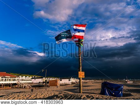 Ijmuiden Beach, The Netherlands August 23, 2020:wooden Flagpole With The Polish, Dutch And The Brazi