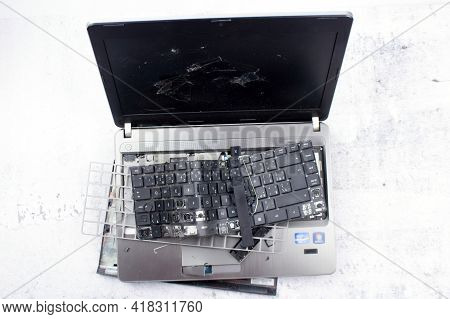 The Laptop Is Smashed To Pieces. The Screen Is Cracked, The Keyboard Is Broken. Electro Waste.