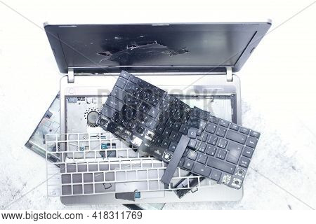 The Laptop Is Smashed To Pieces. The Screen Is Cracked, The Keyboard Is Broken. Electro Waste.