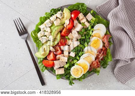 healthy American Cobb salad with egg bacon avocado chicken tomato. hearty keto low carb diet