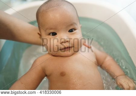 Portrait Of Happy Smiling Asian Baby In Bathtub. Mother Bathing Her Little Son In Bathroom At Home