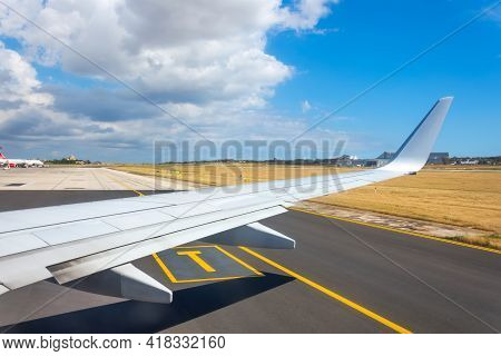 Jet Plane Window Sky View With Machine Wing Between Landing Taxi Way In Airport