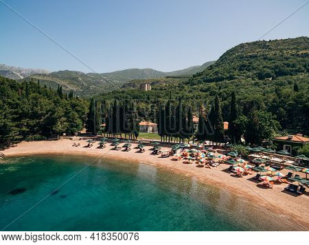 View Of The Royal Beach Of Przno In Montenegro Against The Backdrop Of Green Slopes
