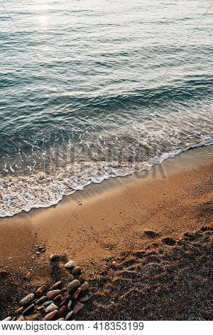 Tidal Bore. The Wave Runs Onto The Beach Where The Stones Lie