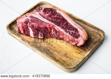Raw Fresh Dry Aged Beef T-bone Steak Set, On Wooden Tray, On White Stone  Background
