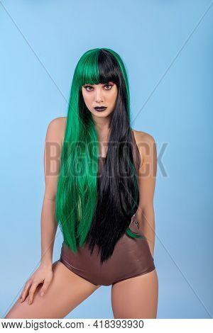 Portrait Of Young Woman Wearing Green Black Halh Color Wig, Black Lips Makeup, Clean Skin. Blue Back