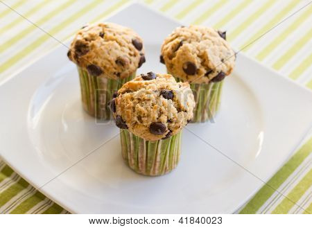 Chocolate Chip Muffins On White Plate And Green Striped Tablecloth