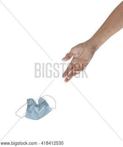 A Lady's Hand Tosses A Used Blue Face Mask Toward A Trash Recepticle Or Similar Target, Isolated On 