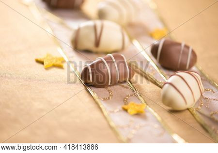 Extreme close up of gourmet date chocolates with confetti. Beautiful photo of exotic date chocolates.