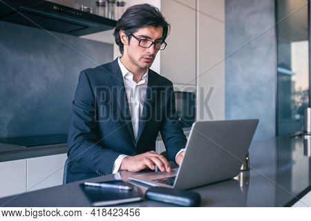 Elegant Businessman Works From Home With A Laptop. Teleworking Concept
