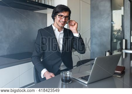 Businessman With Headset At A Video Conference From His Home Computer
