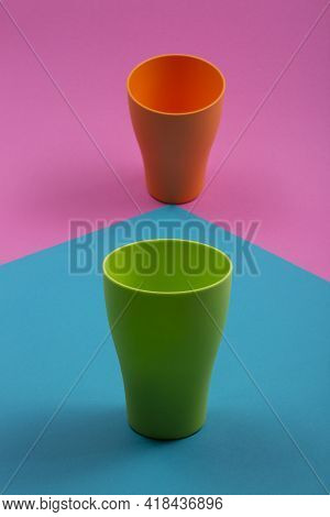 Empty Green And Orange Cups On Colored Background
