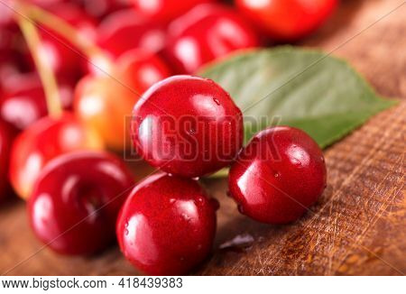 Cherries On Wooden Table With Water Drops Macro Background