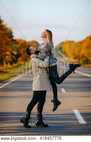 A Happy Couple On An Autumn Road