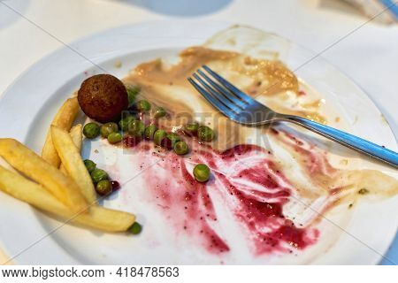 Blurred Picture Of Food Leftovers On A Plate, Dirty Dishes And Unpalatable Food