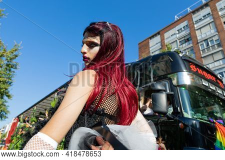 Barcelona - Spain. June 29, 2019: Parade participant in a black guipure dress and white long guipure gloves with a wig of black and crimson hair poses for the cameras with pleasure