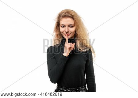 Portrait Of Blonde Girl Keeping Finger At Her Mouth, Saying Shh, Hush, Tsss. Silence And Secret Conc