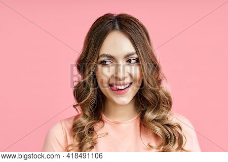 Playful Woman Showing Tongue Lookingaside Over Pink Background