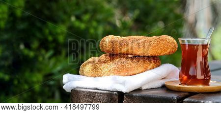 Traditional Turkish Sesame Bagel Simit And Turkish Tea On Wood Background With Hard Sun Light Shadow