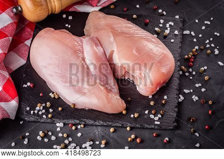 Raw Chicken Fillet On A Dark Stone Background