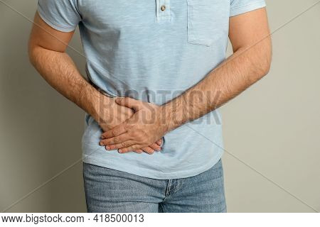 Man Suffering From Acute Appendicitis On Light Grey Background, Closeup