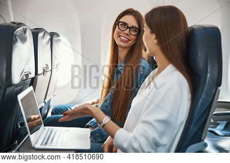 Mirthful Caucasian Ladies Communicating In The Aircraft