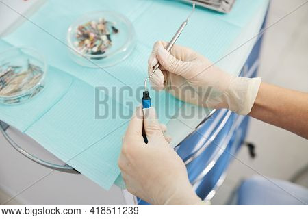 Medic Putting Dental Plugger Into Composite Resins Vial