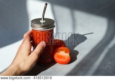 Female Hand Holding Glass Of Tomato Juice. Fresh-squeezed Tomato Juice With Pulp On Trendy Minimal G