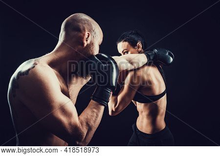 Shirtless Woman Exercising With Trainer At Boxing And Self Defen