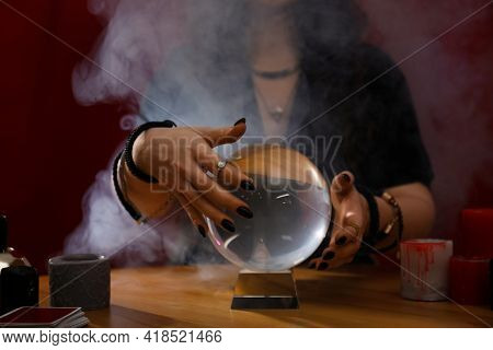 Soothsayer Using Crystal Ball To Predict Future At Table Indoors, Closeup