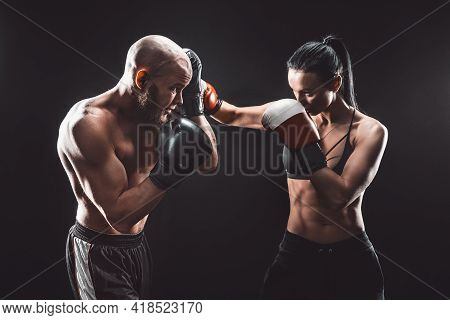 Shirtless Woman Exercising With Trainer At Boxing And Self Defen