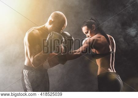 Shirtless Woman Exercising With Trainer At Boxing And Self Defen