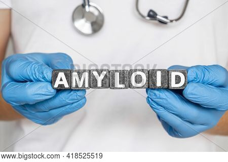 Amyloid - Word From Stone Blocks With Letters Holding By A Doctor's Hands In Medical Protective Glov