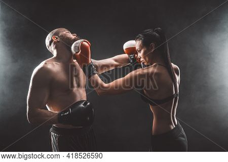 Shirtless Woman Exercising With Trainer At Boxing And Self Defen