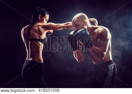 Shirtless Woman Exercising With Trainer At Boxing And Self Defen