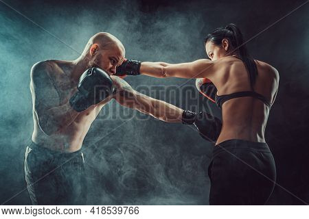 Shirtless Woman Exercising With Trainer At Boxing And Self Defen