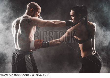 Shirtless Woman Exercising With Trainer At Boxing And Self Defen