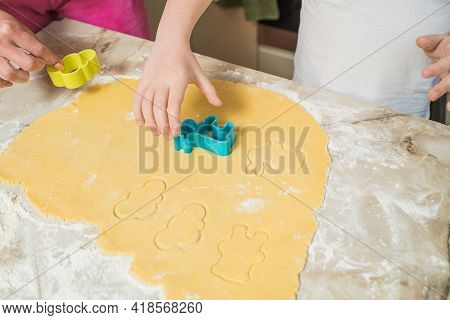 Hands Of Mother And Son Who Squeeze Cookie Figures On The Dough. Cooking At Home
